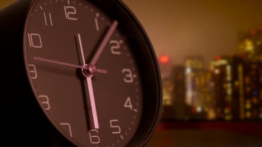 Bulanık bir şehir siluetine karşı gece yapılan detaylı bir yakın çekim sükunet ve zaman geçişini çağrıştırıyor.