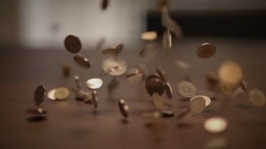 Dinamik bir çekim, paraların ahşap bir yüzeye hızla aktığını, canlı bir şekilde hareket ve para birimini aktardığını gösteriyor.