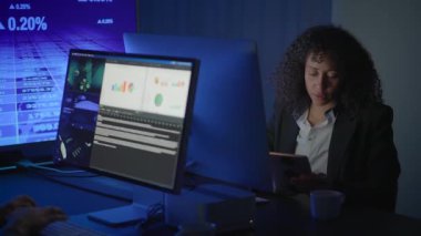 Çağdaş bir ofis ortamında, bir iş adamı bilgisayar kullanarak finansal verileri analiz eder.