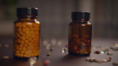 Renkli vitamin ve takviye şişeleri kırsal ahşap bir yüzeye güzelce yerleştirilmiş.