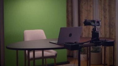 Video içeriği oluşturma ve üretimi için tasarlanmış yeşil ekran, dizüstü bilgisayar ve kamera ile modern bir çalışma alanı