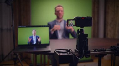 Genç yakışıklı içerik yaratıcısı canlı yayında koçluk videosunda takım elbise giyiyor.