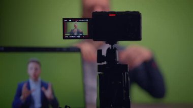 Genç yakışıklı içerik yaratıcısı canlı yayında koçluk videosunda takım elbise giyiyor.