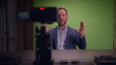 Profesyonel bir konuşmacı, yeşil ekran arkaplanının yer aldığı iyi tasarlanmış bir stüdyoda sunum yapar.