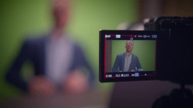 Yeşil ekranın önünde konuşmacıyı gösteren profesyonel bir video kaydını gösteren bir çekim