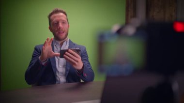 Genç yakışıklı içerik yaratıcısı canlı yayında koçluk videosunda takım elbise giyiyor.