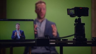 Genç yakışıklı içerik yaratıcısı canlı yayında koçluk videosunda takım elbise giyiyor.