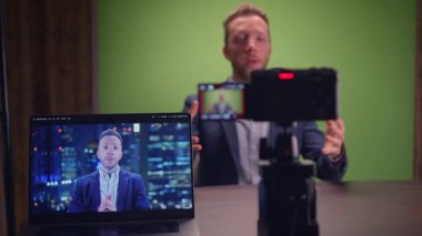 Genç yakışıklı içerik yaratıcısı canlı yayında koçluk videosunda takım elbise giyiyor.