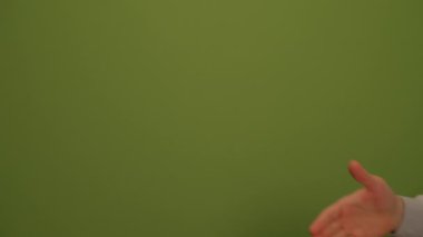 Canlı ve canlı yeşil bir zemin üzerinde açık bir el hareketi sergileniyor. Bu da sıcaklığı ve yakınlığı gösteriyor.