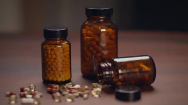 Çeşitli besin takviyeleri şişeleri ve kapsüller kırsal ahşap bir masa üzerinde titizlikle düzenlenmiştir.