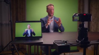 Yetenekli bir konuşmacı, video içeriği oluşturmak için profesyonel bir yeşil ekran kullanarak kameraya iyi bağlanır