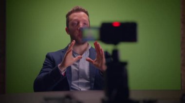 Genç yakışıklı içerik yaratıcısı canlı yayında koçluk videosunda takım elbise giyiyor.