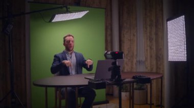 Genç yakışıklı içerik yaratıcısı canlı yayında koçluk videosunda takım elbise giyiyor.