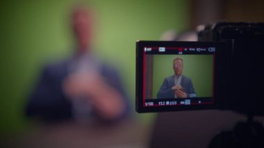 Bulanık sunuculu ve video çekimleri için yeşil ekranlı profesyonel bir prodüksiyon kurulumu hayal edin.