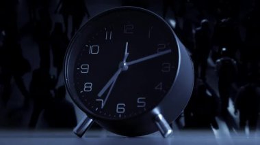 Zarif ve sofistike bir siyah alarm saati, gölgeli bir arka plana yerleştirilmiş modern bir tasarım sergiliyor.