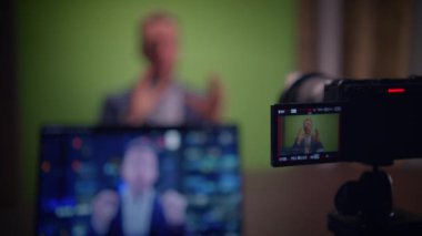 Profesyonel bir sunucu yeşil ekran ve dijital ekran kurulumu kullanarak içeriği çekiyor