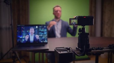 Bir vlog kaydedicisi içeriği yeşil bir ekran ve bir Wellorganize kamera ve dizüstü bilgisayar kurulumu ile meşgul