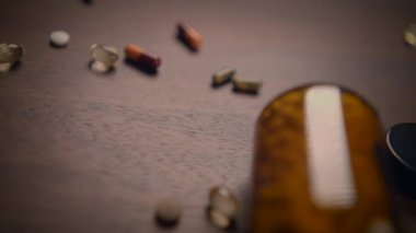 Çarpıcı bir yakın plan görüntüsü çeşitli hapları ve kapsülleri alıp kırsal ahşap arka planda zevkle dağıtıyor.