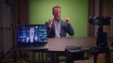 Çağdaş bir video kayıt kurulumunda bir hoparlör, bir laptop ve canlı bir yeşil ekran arkaplanı sergileniyor.
