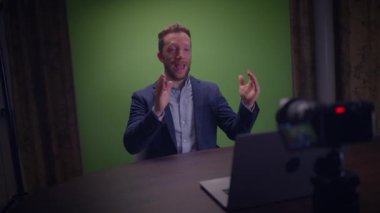 Genç yakışıklı içerik yaratıcısı canlı yayında koçluk videosunda takım elbise giyiyor.