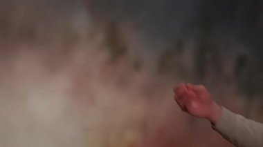 Yumuşak renklere sahip soyut bir arkaplan ve yaratıcılığı ve ifadeyi sembolize eden bir el hareketi..