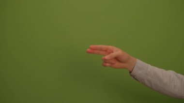İfade eden bir el hareketi, kendinden emin bir şekilde, canlı ve canlı yeşil bir arkaplana karşı yapılır.