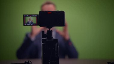 Genç yakışıklı içerik yaratıcısı canlı yayında koçluk videosunda takım elbise giyiyor.
