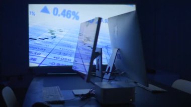 Çeşitli finansal veri eğilimlerini gösteren ikili monitörlerle donatılmış modern ve gösterişli bir ticaret alanı