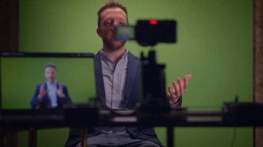 Genç yakışıklı içerik yaratıcısı canlı yayında koçluk videosunda takım elbise giyiyor.