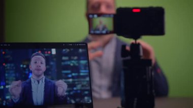 Genç yakışıklı içerik yaratıcısı canlı yayında koçluk videosunda takım elbise giyiyor.