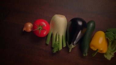 Canlı ve renkli bir taze, besleyici sebze koleksiyonu kırsal ahşap bir yüzeyde ustalıkla düzenlenmiştir.