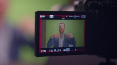 Genç yakışıklı içerik yaratıcısı canlı yayında koçluk videosunda takım elbise giyiyor.