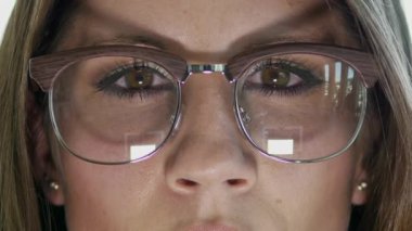 Şık ve şık gözlükler takan bir kadının yoğun bakışlarını vurgulayan çarpıcı yakın plan fotoğrafı.