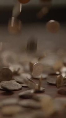 Dinamik bir çekim çok sayıda madeni parayı yakalar ve desenli bir yüzey boyunca dökülür.