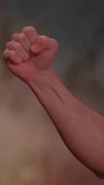 Sıkıca sıkılmış bir yumruğun detaylı bir görüntüsü gücü, dayanıklılığı ve sarsılmaz kararlılığı simgeliyor.