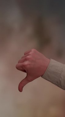 Ayrı bir baş parmak aşağı hareket, geniş bir bağlamdaki hoşnutsuzluğu veya olumsuzluğu açıkça sembolize eder.