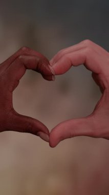 İki el bir araya gelerek güzel bir kalp şekli oluşturur. Aşkı, birlikteliği ve çeşitliliği sembolize eder.