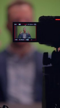 Yetenekli bir film yapımcısı canlı yeşil ekran arkaplanı önünde özenle ilgi çekici bir video segmenti kaydediyor.