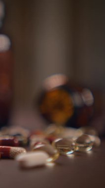 Çeşitli haplar ve vitaminler yumuşak odaklı arka plan ayarları içinde zarif bir şekilde sergilenir.