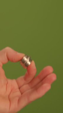 Zarif bir el, yemyeşil bir zemine karşı çarpıcı bir gümüş yüzük sergiliyor, zamansız stili simgeliyor.