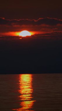 Şok edici bir günbatımı sakin suları yansıtıyor, bu anları seven doğa meraklıları için mükemmel.