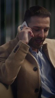 Takım elbiseli bir adam telefonda konuşuyor, modern bir şehir ortamında profesyonellik ve entelektüellik yayıyor.