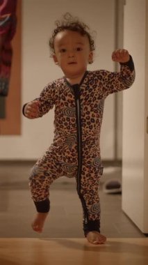 Sevimli küçük bir bebek, eğlenceli ve şirin bir leopar desenli tulum giyerek mutlu bir şekilde evin içini keşfediyor.
