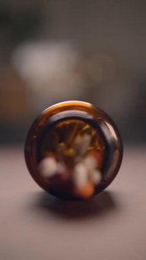 Canlı kapsüllerle dolu kahverengi cam bir şişenin detaylı bir görüntüsü, sağlık ve sağlık temaları için ideal..