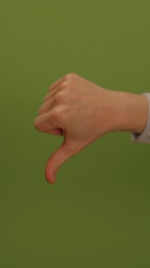 Canlı ve canlı yeşil bir arkaplanda belirgin bir şekilde baş parmağını gösteren bir insan eli.