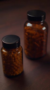 Çeşitli besin maddeleriyle dolu iki cam şişe kırsal ahşap arka planda sergileniyor.