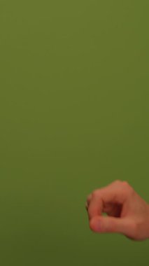 Küçük yeşil bir bitkiyi nazikçe tutan bir elin detaylı yakın plan görüntüsü, yatıştırıcı yeşil bir arka plana güzelce yerleştirilmiş.