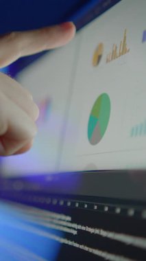 Ekrandaki veri görselleştirmesine işaret eden bir parmak yakın plan, detaylı analiz ve bilgiyi vurguluyor