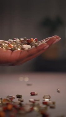 Bir el zarif bir şekilde çeşitli kapsüller ve haplardan oluşan canlı bir çeşitlilik sergiliyor, sağlığı ve genel sağlığı simgeliyor.