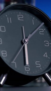 Klasik bir siyah masa saatinin yakın plan görüntüsü rafine tasarımını ve kristal berrak zaman gösterimini sergiliyor.